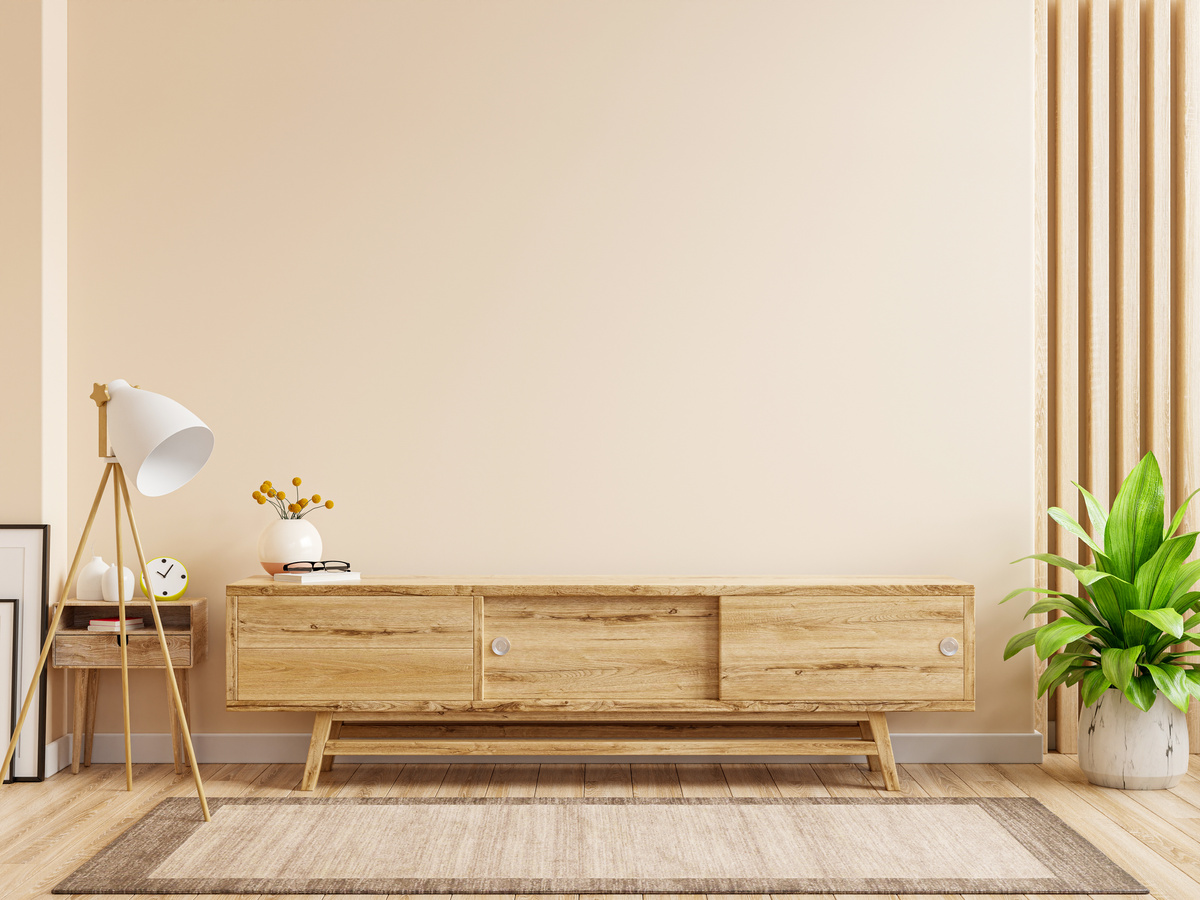 TV cabinet with cream color wall and wood flooring.